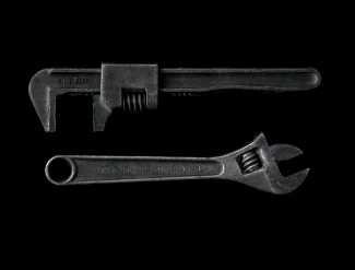 Wrench and adjustable spanner on black background - tools used by emergency plumbers in London